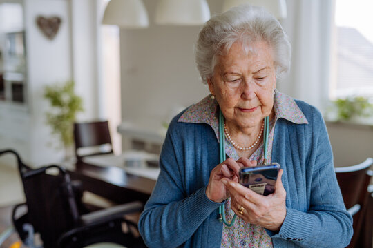En gammal kvinna som använder en smartphone